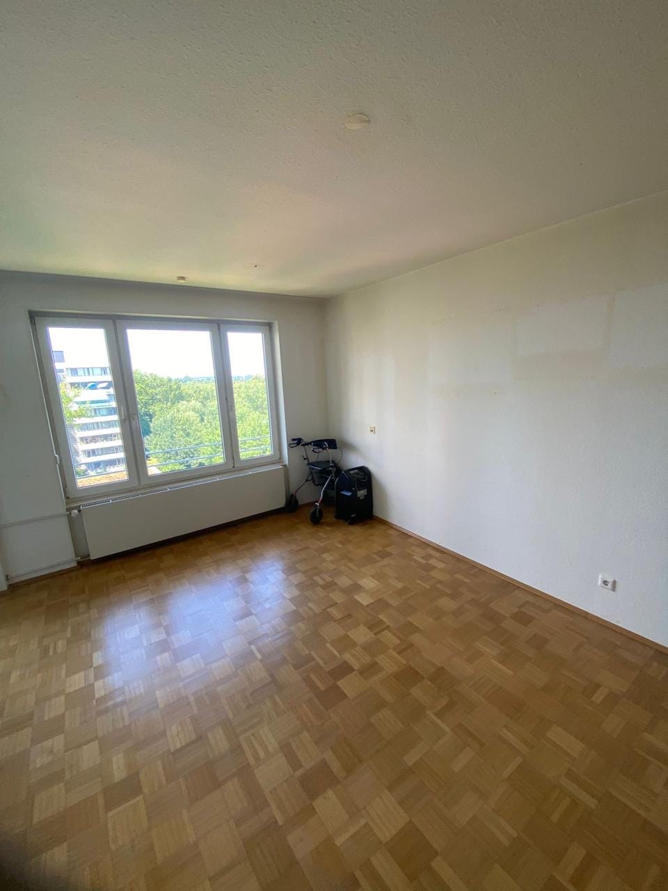 Leergeräumte Wohnung mit besenreinem Parkettboden nach der Räumung
